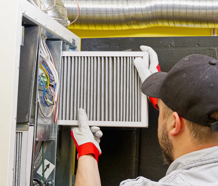 Technician replacing a furnace air filter