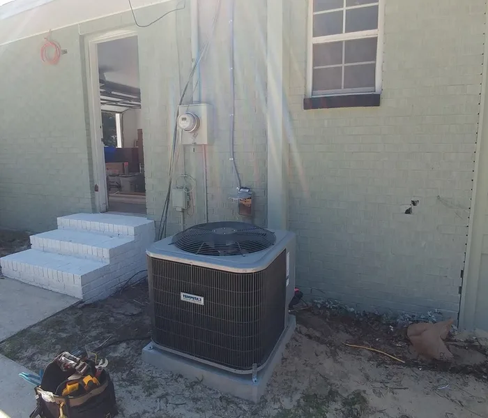 Heat pump condenser installed beside a home