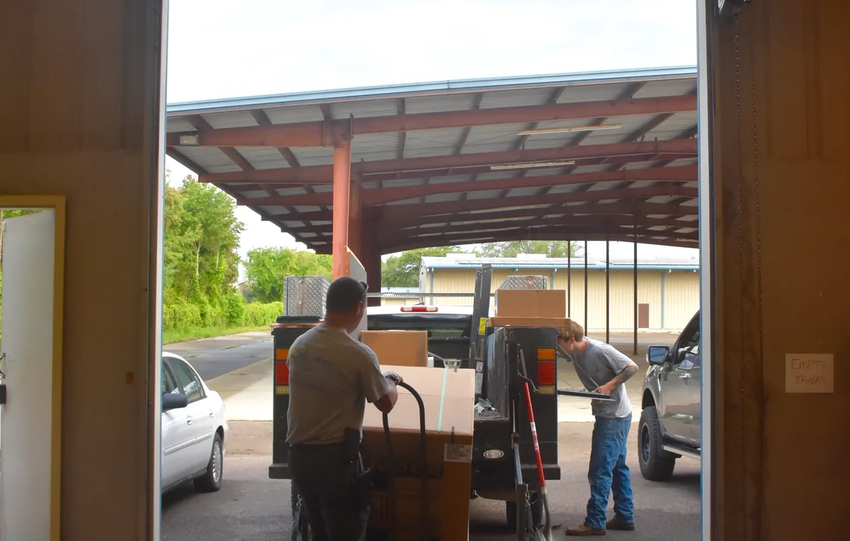 Lake Area Heating & Air crew unloading HVAC equipment at the shop