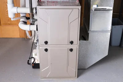Technician servicing a residential furnace in a utility closet
