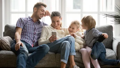 Family relaxing together on a couch in a comfortable, climate-controlled home