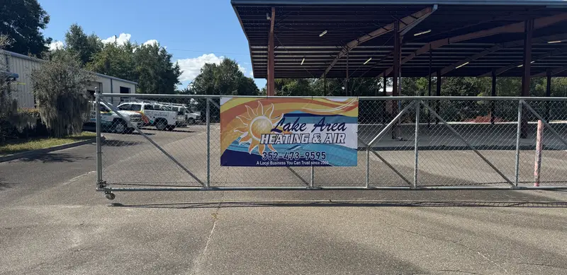 Lake Area Heating & Air banner on the gate of the company&rsquo;s equipment lot