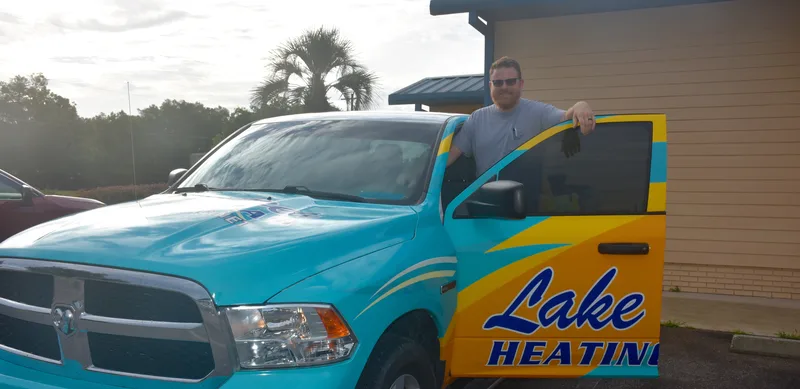 Lake Area Heating & Air technician beside the company&rsquo;s turquoise service truck